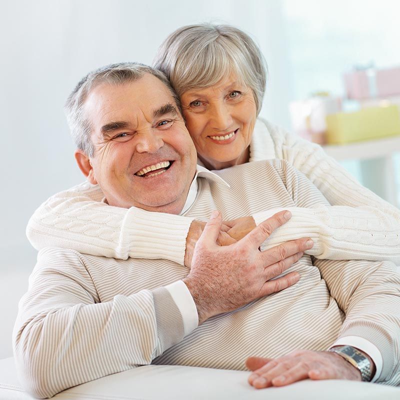 Счастливая и здоровая пожилая пара использующая Нутримун улыбаются в камеру